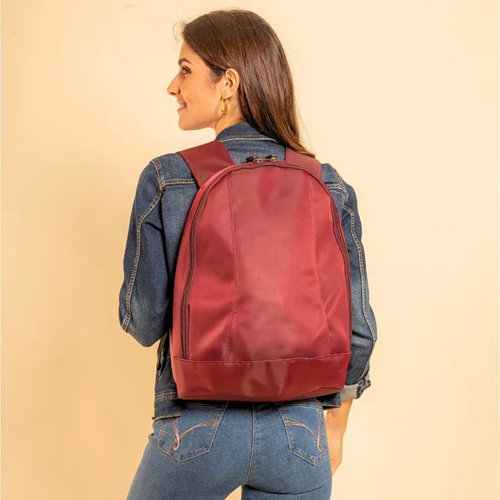 Female wearing a red arsayo backpack against a beige background