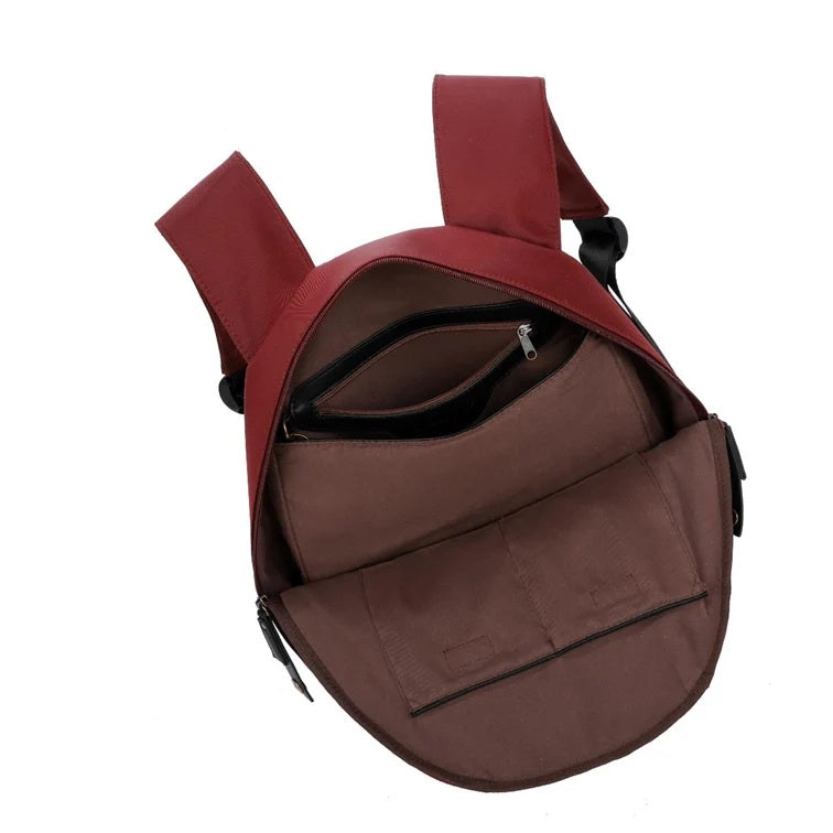Burgundy backpack open on white background
