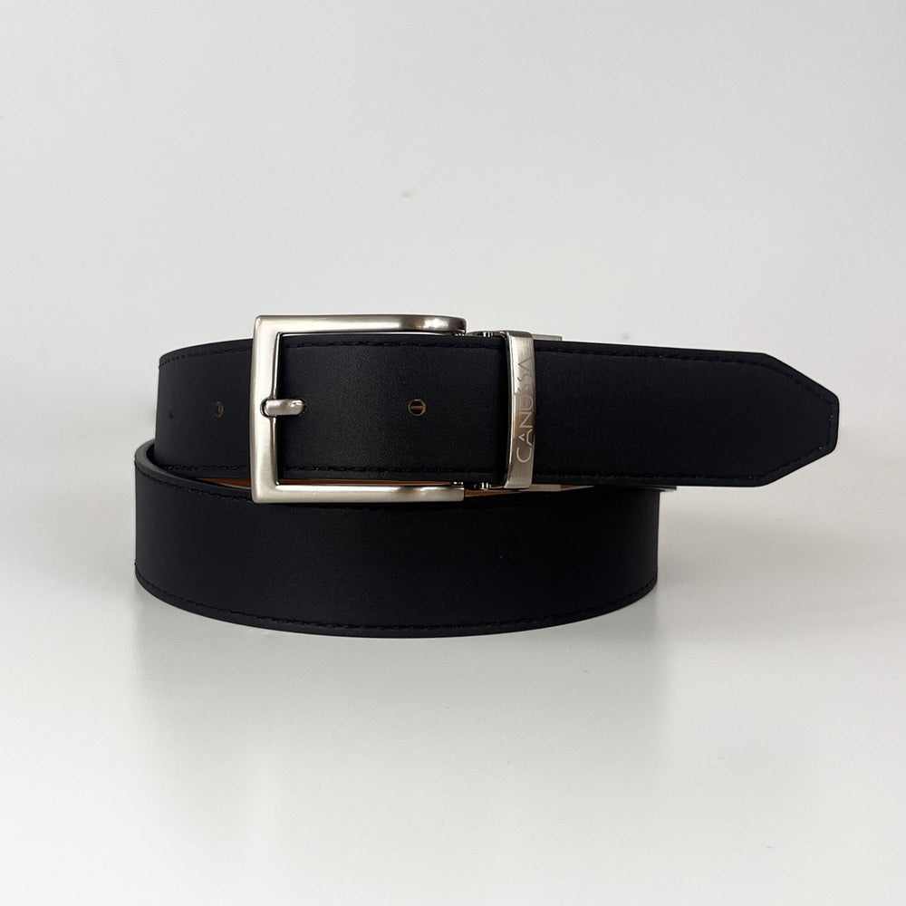 Black white reversible vegan 
belt with silver buckle on a light gray background